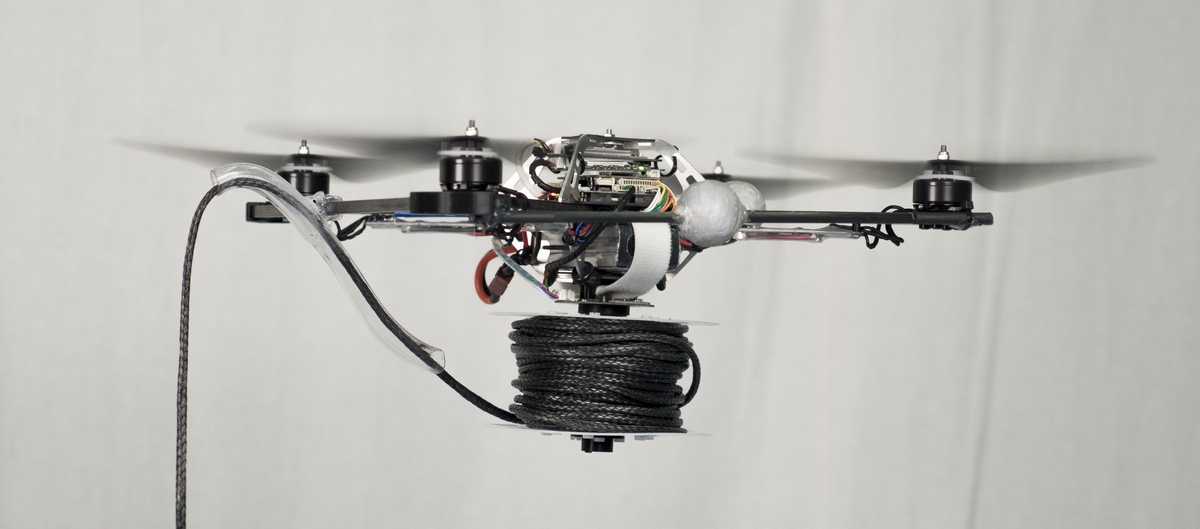 A quadcopter with a motorized spool containing rope.