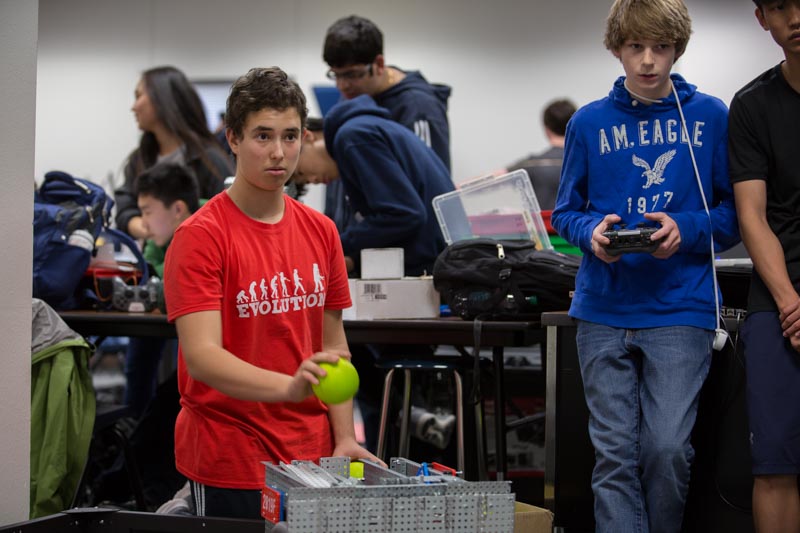 Philip loads a ball onto his robot during practice.